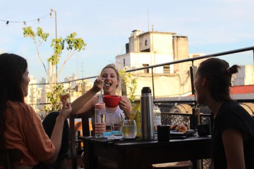 a group of women sitting at a table eating food at Parla Hostel in Buenos Aires