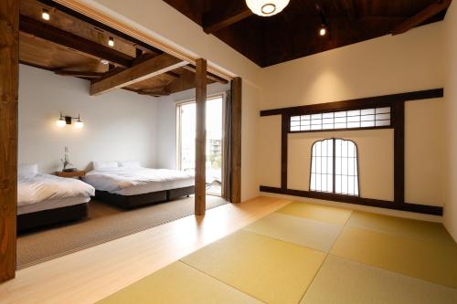 a bedroom with two beds and a window at 貸別荘 楓-Fū- 有馬 in Arima