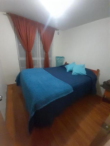 1 dormitorio con cama azul y manta azul en Departamento Vallenar en Vallenar