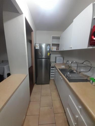 eine Küche mit einem Kühlschrank und Fliesenboden in der Unterkunft Departamento Vallenar in Vallenar