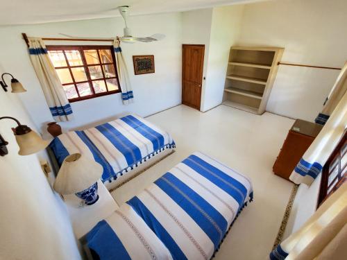 una camera da letto con due letti e una lampada di Villa Casalet a Puerto Escondido