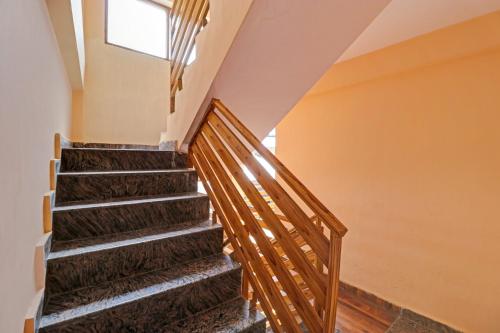 - un escalier dans une maison avec une fenêtre dans l'établissement OYO Flagship Aman Cottage, à Manali
