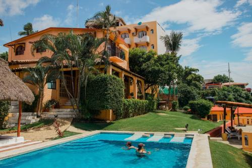 a house with a swimming pool in front of a building at Villa Casalet in Puerto Escondido