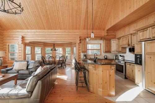 eine Küche und ein Wohnzimmer in einem Blockhaus in der Unterkunft Fiddler Lake Resort Chalet 47 Deer in Mille-Isles