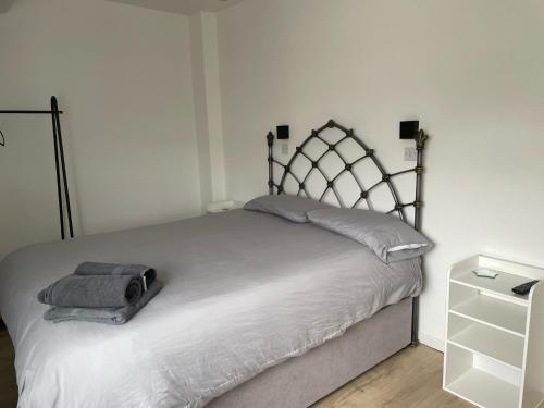 a bedroom with a white bed with a metal frame at Fern House - free off road parking included in Buxton