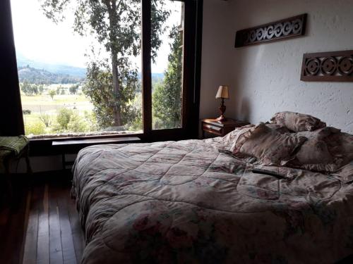 ein Schlafzimmer mit einem großen Bett und einem großen Fenster in der Unterkunft Casa Heesen Mague in Susa
