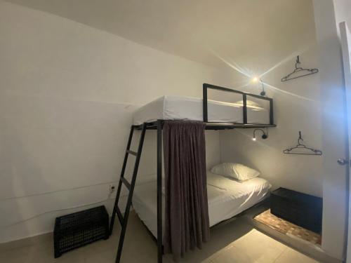 a bunk bed in a small room with a ladder at The Hostal Inn in Playa del Carmen