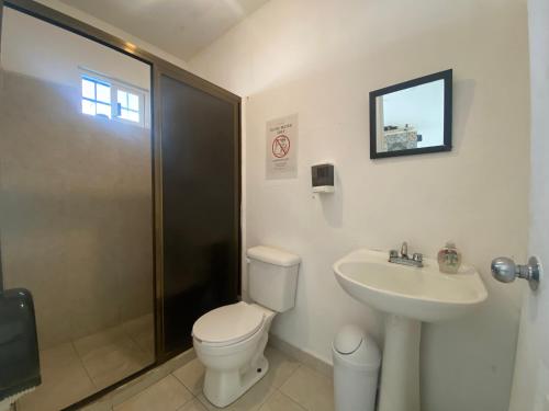 a bathroom with a toilet and a sink and a shower at The Hostal Inn in Playa del Carmen