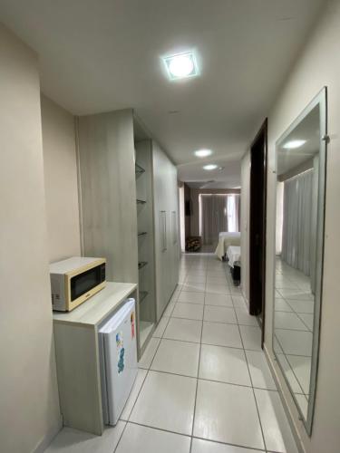 a hallway of a room with a microwave on a counter at Recife Flats Beach Class Internacional in Recife