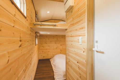 um quarto com painéis de madeira e uma cama numa pequena casa em Togakushi Campsite - Vacation STAY 42172v em Shinano