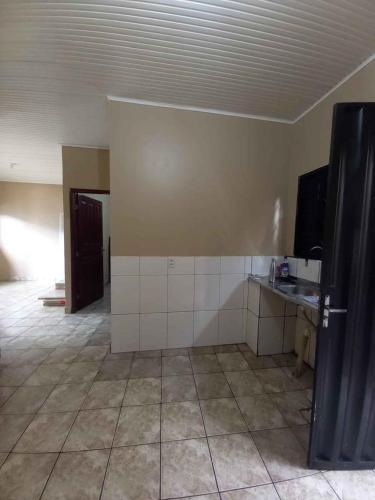 an empty room with a kitchen with a black refrigerator at Residencial in Altamira