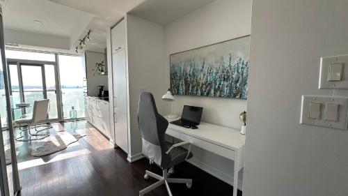 a white office with a desk and a laptop computer at DOWNTOWN, LUXURY CONDO, CN TOWER, ROGERS CENTER, SCOCIA ARENA, UNOBSTRUCTED VIEW in Toronto