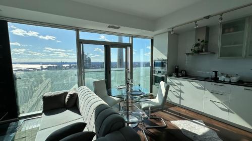 a living room with a couch and a table at DOWNTOWN, LUXURY CONDO, CN TOWER, ROGERS CENTER, SCOCIA ARENA, UNOBSTRUCTED VIEW in Toronto