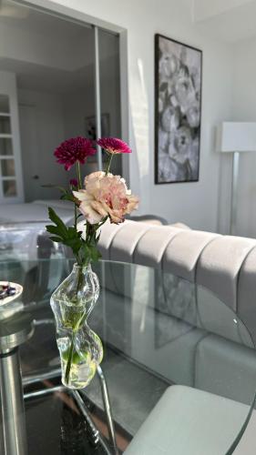 a vase with purple flowers sitting on a glass table at DOWNTOWN, LUXURY CONDO, CN TOWER, ROGERS CENTER, SCOCIA ARENA, UNOBSTRUCTED VIEW in Toronto