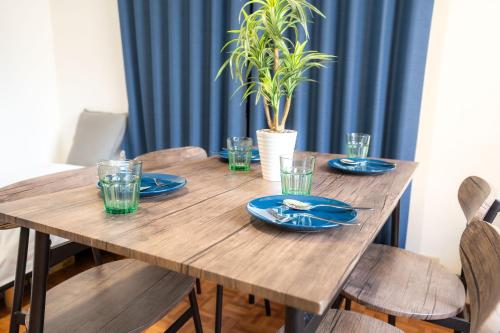 a wooden table with blue plates and glasses on it at 3BR Entire House for7 #91Rated TraditionCozy Japanese Villa in Ikebukuro 6mins St in Tokyo