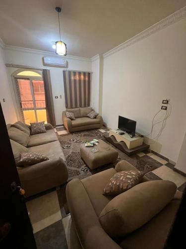 ein Wohnzimmer mit Sofas und einem Laptop auf dem Tisch in der Unterkunft شقة الزقازيق in Manshīyat as Sādāt