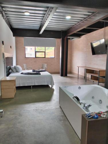 a bedroom with a bed and a bath tub at Hotel El Cordobes in Marinilla