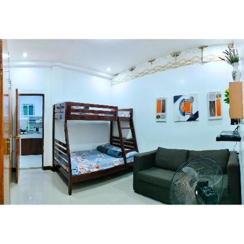 a living room with a bunk bed and a couch at City Center Transient House - Studio Type in Baguio
