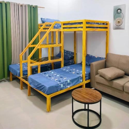 a room with two bunk beds and a couch at City Center Transient House - Studio Type in Baguio