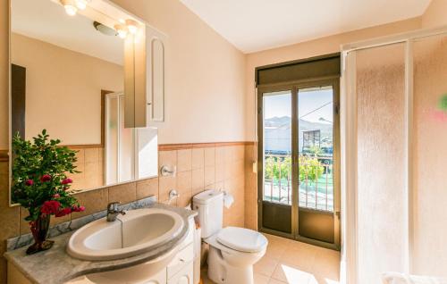 baño con lavabo y aseo y ventana en Nice Home In Alcala La Real With Kitchen, en Alcalá la Real