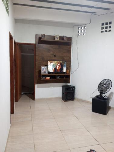 Habitación con TV de pantalla plana en la pared en Casa temporada 2 quartos, en Serra