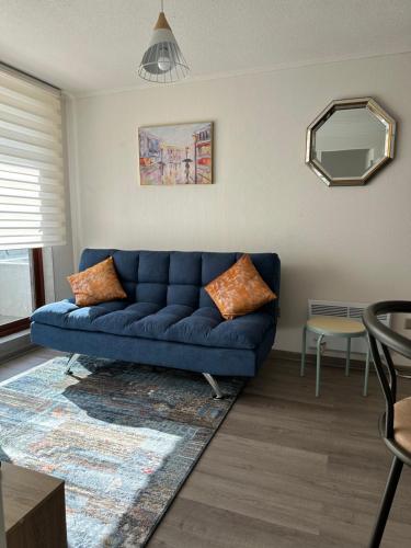 a blue couch in a living room with a mirror at Depto Nuevo Chillan Centro 2D-2B-E privado in Chillán