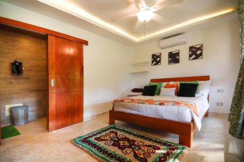 a bedroom with a bed and a wooden closet at Villa loren A3 in Las Terrenas