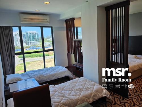 Kota Kinabalu City Ensuite by MSR at SCSP Ming Garden في كوتا كينابالو: غرفة فندقية بسريرين ونافذة