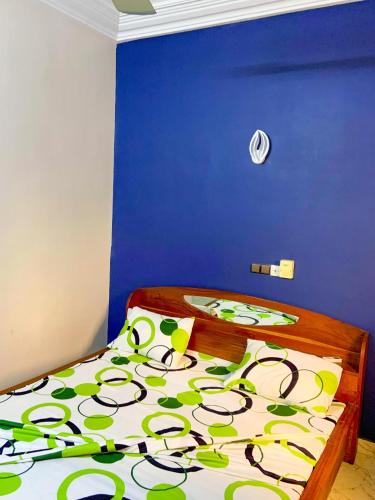 um quarto com uma cama com uma parede azul em Résidencesdavelsa em Cotonou