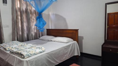 um quarto com uma cama com uma cortina azul e uma cortina azul em The Leisure Homestay Ella Bandarawela em Bandarawela