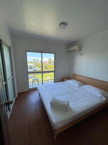 um quarto com uma grande cama branca e uma varanda em Easy Apt em Suva
