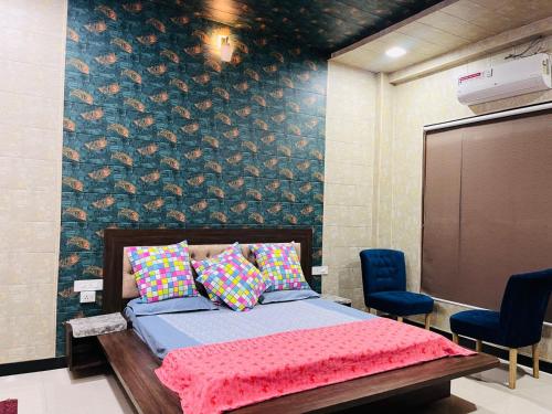 a bedroom with a bed and two blue chairs at Shreshth Home Stay - Best Family Accommodation - 3km from Har Ki Pauri, Haridwar, Uttarakhand in Haridwār