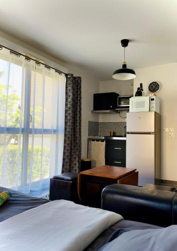 - un salon avec un réfrigérateur et une table dans l'établissement Studio à Aix-en-Provence., à Aix-en-Provence