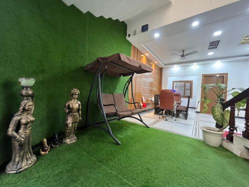 a living room with a green wall and an umbrella at Shreshth Home Stay - Best Family Accommodation - 3km from Har Ki Pauri, Haridwar, Uttarakhand in Haridwār