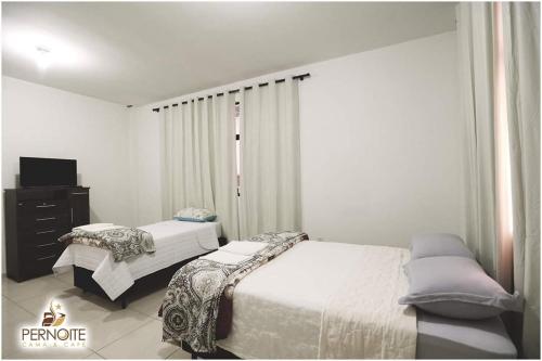 a bedroom with two beds and a tv in it at Hotel pernoite in Pato Branco