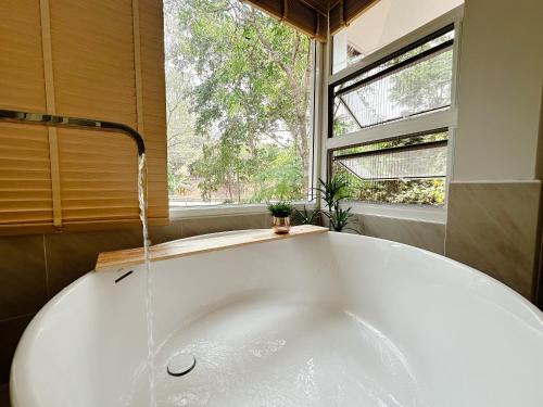 a bath tub in a bathroom with a window at Arb Pa Home and Cafe @ Mae on in Chiang Mai
