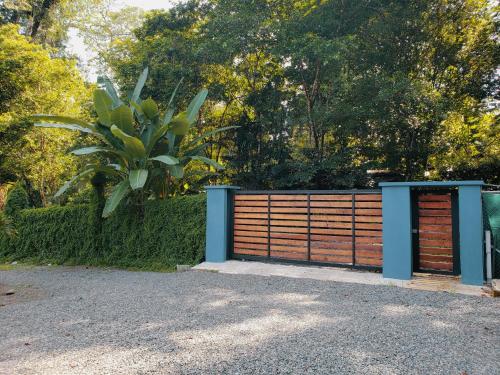 a wooden fence with a gate and a tree at Villa Akala in Cocles
