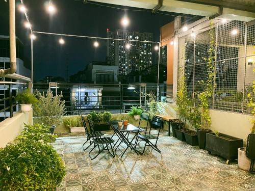 un patio con tavolo e sedie su un balcone di notte di Larita Saigon ad Ho Chi Minh