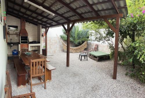 patio con pergolato in legno e tavolo di Recanto do Mica a Governador Celso Ramos