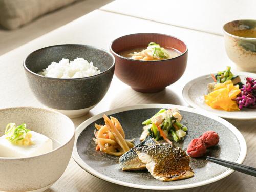 a table with plates of food and bowls of rice at ORIENTAL HOTEL KYOTO ROKUJO in Kyoto