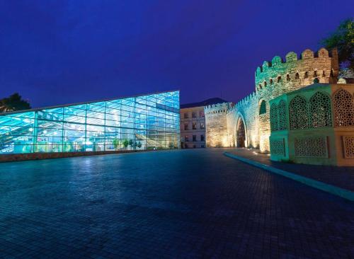 a large building with a glass facade at night at Revelton Baku Studios in Baku