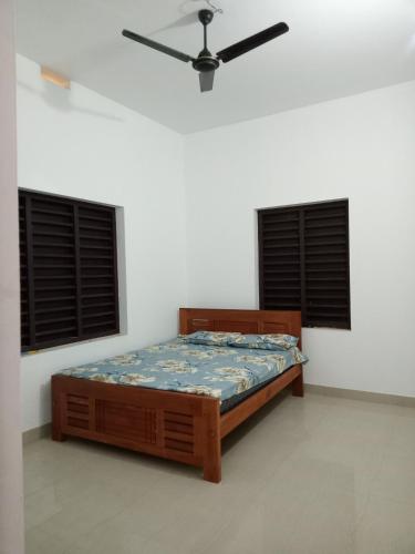a bedroom with a bed and two windows at Kavvayi Kayaloram The Arabian Beach House in Kokkānisseri