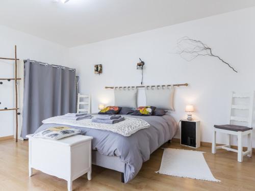 une chambre blanche avec un lit et une table dans l'établissement Gîte rénové avec jardin près des marais, à 10 km des plages, acceptant les animaux - FR-1-306-1269, à Bourgneuf-en-Retz