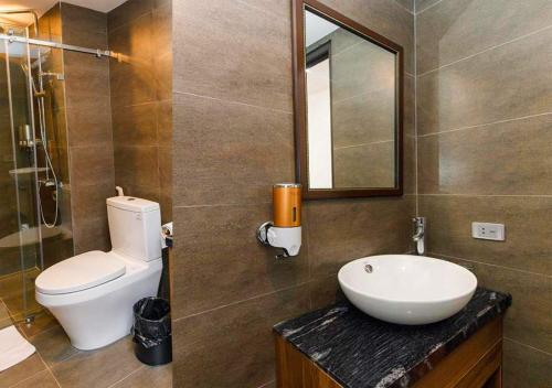 a bathroom with a toilet and a sink and a mirror at Family Hanoi Hotel in Hanoi