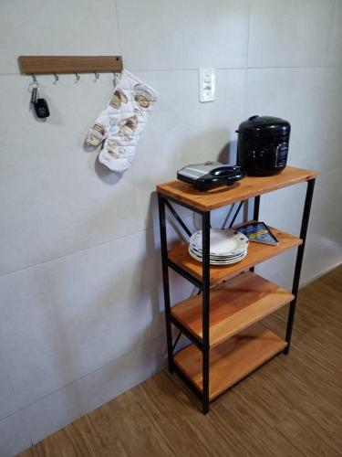 a shelf with plates and shoes on a wall at Apartamento Premium em Penedo in Penedo