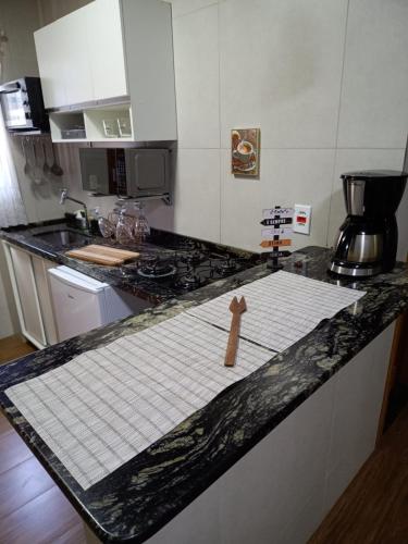 a wooden person sitting on top of a kitchen counter at Apartamento Premium em Penedo in Penedo