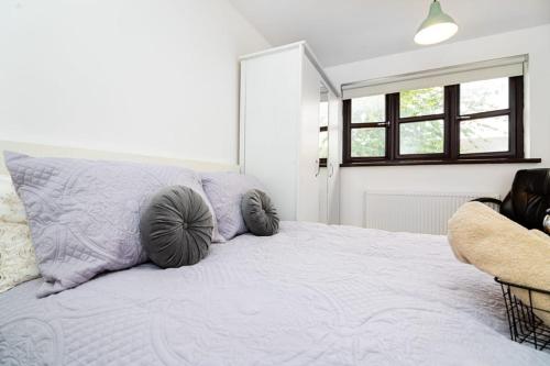 a bedroom with a large bed with pillows on it at Immaculate Refurbished House in London
