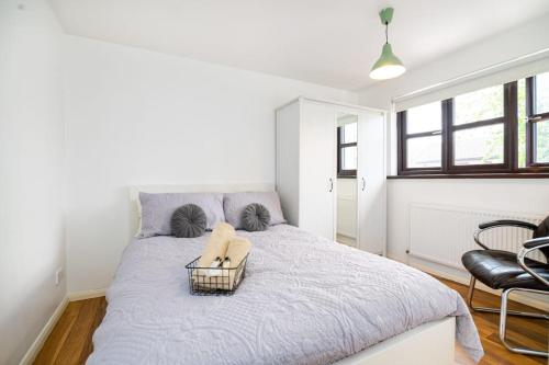 a bedroom with a bed with a basket on it at Immaculate Refurbished House in London