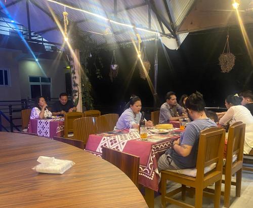 a group of people sitting at tables in a restaurant at Hotel Safari Suite in Sauraha