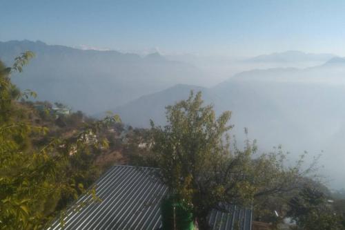 - une vue sur la montagne avec une maison et un arbre dans l'établissement Mountain View, à Tehri-Garhwāl